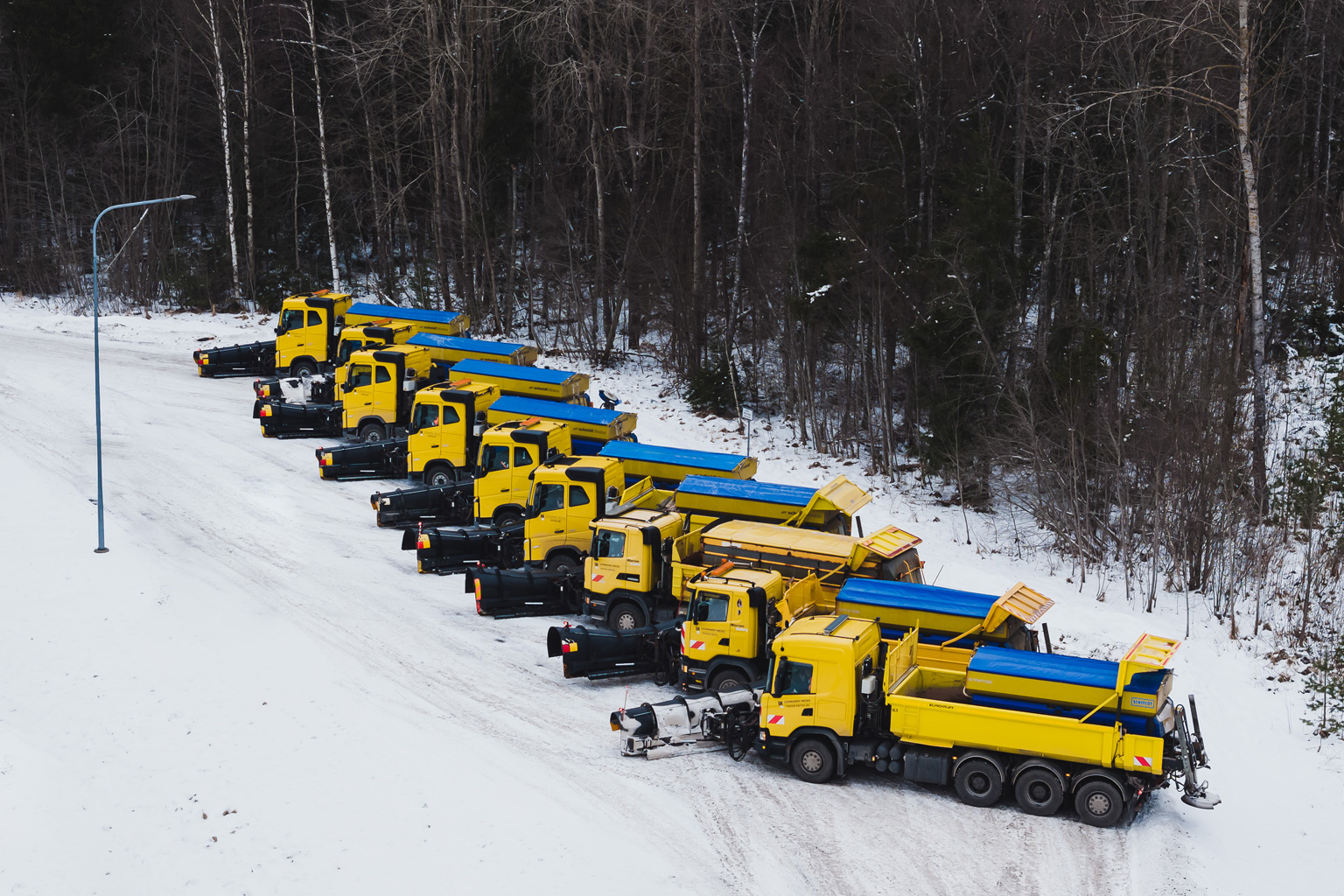 side view of nine trucks in snow